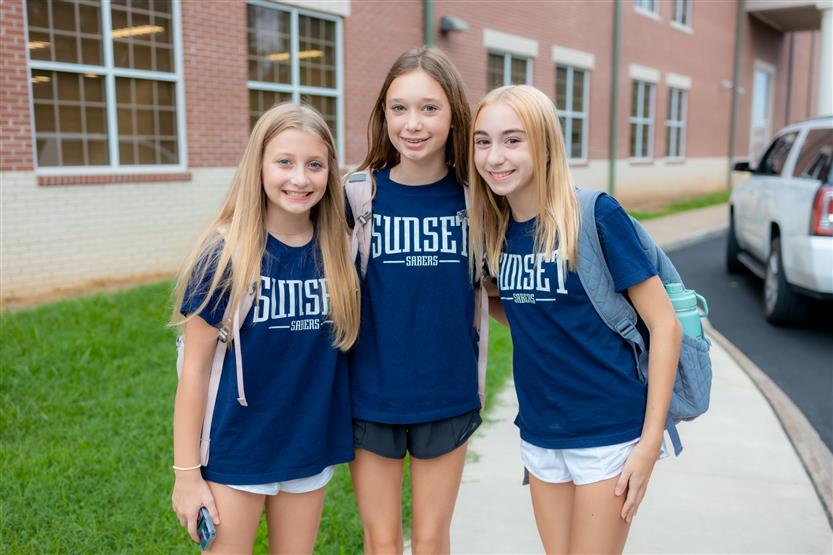Three cheerleaders smile